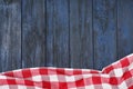 Checkered picnic blanket on color wooden background, top view