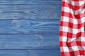 Checkered picnic blanket on color wooden background. Space for text Royalty Free Stock Photo