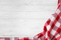 Checkered picnic blanket on wooden background, top view