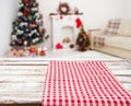 Checkered red tablecloth on wooden table on blurred holiday interior, new year and christmas concept, tablecloths Royalty Free Stock Photo