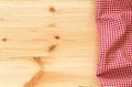 Checkered red and white napkin or folded tablecloth on wooden ba