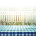 Checkered tablecloth on blur of white fence and garden background Royalty Free Stock Photo