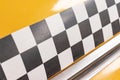 Checkered taxi sign on a yellow taxi car doors close up