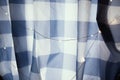 Checkered white and blue curtain with electric LED garland lights. Morning light through tartan blinds. Cozy vintage Royalty Free Stock Photo