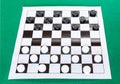 Checkers on black and white checkered sheet board Royalty Free Stock Photo