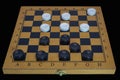 Checkers Board Game. Board with checkers isolate on a black background close-up Royalty Free Stock Photo
