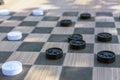 Checkers game made from carved wood. Outdoors board game. Free entertainment for citizens in city park