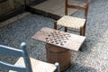 Checkers game made from wood and corn cob pieces on a barrel with chairs