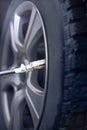 Checking and adjusting pressure for car tyre. Royalty Free Stock Photo