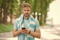 Checking all training updates. Man athlete setting up fitness tracker with smartphone app, nature background. Sportsman Royalty Free Stock Photo