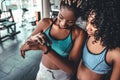 Checking all updates. Beautiful and young woman looking at her sport bracelet while standing at gym. Fitness concept Royalty Free Stock Photo