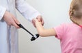Checking the child`s elbow reflex with a neurological hammer, close-up. Nervous system Royalty Free Stock Photo