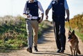 Checking the crimescene. policemen and their dog walking down a dirt road.