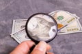 Checking dollar bill for authenticity with magnifying glass Royalty Free Stock Photo