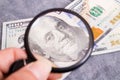 Checking dollar bill for authenticity with magnifying glass Royalty Free Stock Photo