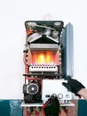 Checking double-circuit gas boiler with open lid and fire. Cleaning before season. Royalty Free Stock Photo