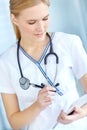 Checking the files. a nurse writing notes in her notepad. Royalty Free Stock Photo