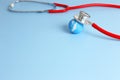 Checking health with red stethoscope on earth. World health day concept - blue earth with on light blue background