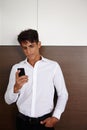 Checking his messages. a handsome young businessman checking his cellphone at the office. Royalty Free Stock Photo