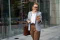 Checking important email. Portrait of a confident attractive business woman in classic wear using smartphone on the way Royalty Free Stock Photo