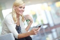 Checking my messages. A beautiful young woman reading a text message while holding a take away coffee. Royalty Free Stock Photo