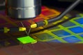 Close up of examining a sample of OLED display with probe station under the microscope in laboratory.A semiconductor on a silicon