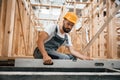 Checking the straight by using leveling tool. Industrial worker in wooden warehouse Royalty Free Stock Photo