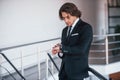 Checking time. Portrait of handsome young businessman in black suit and tie Royalty Free Stock Photo