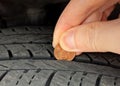Checking tire tread depth/wear with a penny.  Tire safety and maintenance Royalty Free Stock Photo