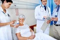 Checking up on her meds. three doctors attending a senior patient who is in a hospital bed. Royalty Free Stock Photo