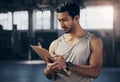 Checking up on his training inventory. a muscular young man writing notes on a clipboard while working in a gym. Royalty Free Stock Photo