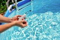 Checking the water quality of a pool with the help of a test strip with PH value, chlorine and algaecide Royalty Free Stock Photo