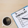 Checklist box on clipboard with pen and coffee cup on wooden table. check choice answer test. checklist information writing