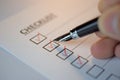 Checklist concept - checklist box with red checkmark, paper and a pen with checklist word on table Royalty Free Stock Photo