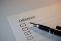 Checklist concept - checklist box with red checkmark, paper and a pen with checklist word on table Royalty Free Stock Photo