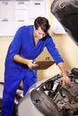 Checklist, man and mechanic check engine of car, repair or maintenance. Clipboard, technician and serious person on Royalty Free Stock Photo