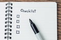 Checklist with marker pen and check box on small notepad on wood table, to do list, prioritize or reminder for project or plan