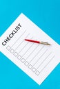 Checklist and pen on blue background top view copy space
