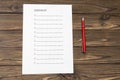 Checklist on a sheet of paper, fountain pen on the background of a wooden table Royalty Free Stock Photo