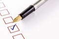 Checklist with a ticked box and a pen on white paper. Royalty Free Stock Photo