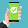 Checkmark on smartphone screen. Hand holding smartphone with green tick. Phone surveys technology, website app testing