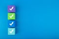 Checkmarks on four toy blocks on blue background with copy space