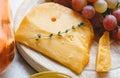 Cheddar cheese with grapes, pink wine, honey. Wine cheese snacks for a romantic dinner. Aged dutch gouda cheese on cheeseboard