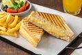 Cheddar cheese toast with french fries and salad on wooden table Royalty Free Stock Photo