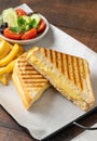 Cheddar cheese toast with french fries and salad on wooden table Royalty Free Stock Photo