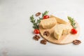 Cheddar and various types of cheese with rosemary and tomatoes on wooden board on a white background . Side view, copy space Royalty Free Stock Photo