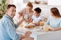 Cheeful man having breakfast with his family