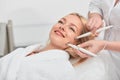 Cheeful smiling awesome blonde woman having microcurrent medicine treatment.