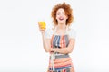 Cheeful woman laughing and holding glass of orange juice