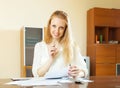 Cheeful woman reading documents at home